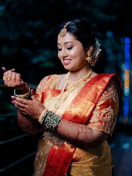 A candid shot of this beautiful bride, ready for her Muhurtham. The makeup is designed to look flawless and radiant, even in natural light.
