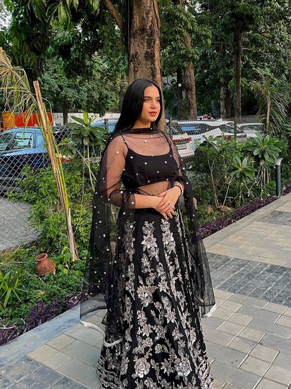 The same beautiful black lehenga, this time paired with a custom-stitched sheer blouse with delicate pearl work. This adds a touch of elegance and offers more coverage.