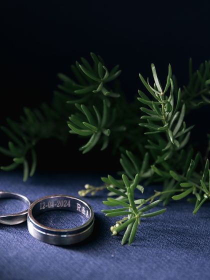 A beautifully styled shot of the wedding bands, engraved with the special date. We take care to capture these small but significant details in an artistic way.