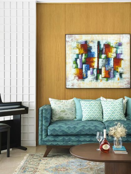 This living room is a symphony of prints and patterns. I paired a bold teal sofa with a colorful abstract painting and a neutral rug, creating a space that feels vibrant, personal, and full of character.