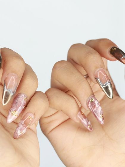 A close-up shot of the pink marble and chrome nails, highlighting the details and textures.