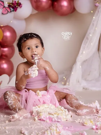It's cake smash time! This little girl is enjoying every bit of her yummy pink cake.