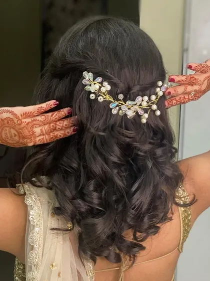 A beautiful shot of the hairstyle for this look. The soft curls are gathered with a delicate hair accessory, adding a touch of romance to the overall style.