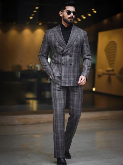 A dynamic walking shot of a model in a plaid suit. This image demonstrates movement and poise, a key shot for any model's portfolio to show how they carry themselves in formal wear.