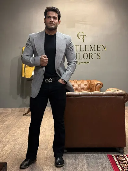 A grey patterned blazer with a wide peak lapel, offering a modern and sharp look. Here it is styled casually with a black t-shirt and jeans.
