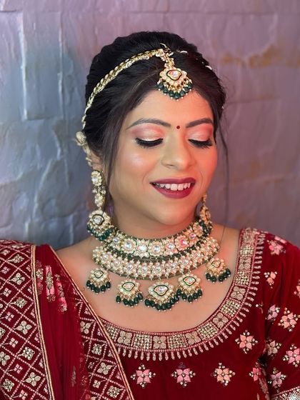 A client looking stunning in a traditional bridal rental set. This heavy choker with green beads and matching headpiece is perfect for a bride who wants a complete, coordinated look for her big day.