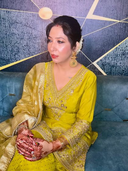 A seated portrait showing the intricate details of her outfit and the flawless finish of her makeup.