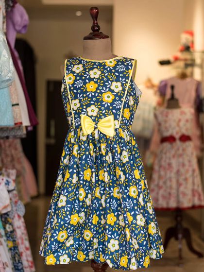 A bold and beautiful floral dress in navy and yellow. The simple A-line cut allows the vibrant pattern and bright yellow piping to really stand out.