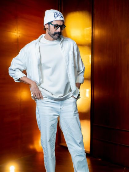 Another look at the layered, all-white outfit. The combination of different fabrics and clean lines showcases the versatility and impact of monochromatic styling.