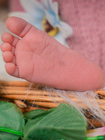 Ten tiny toes. I always make sure to get detailed shots of your baby's little feet and hands. This close-up shows a newborn's foot resting on a woven basket.