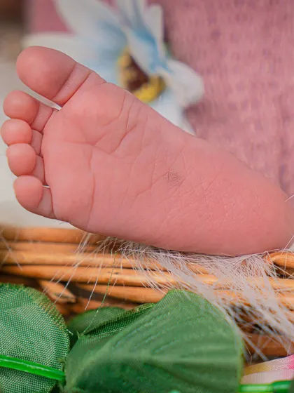 Ten tiny toes. I always make sure to get detailed shots of your baby's little feet and hands. This close-up shows a newborn's foot resting on a woven basket.