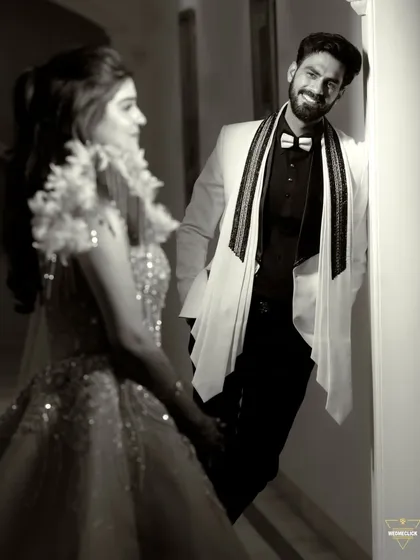 A candid and playful moment between the couple, the groom's smiling face looking at his bride.