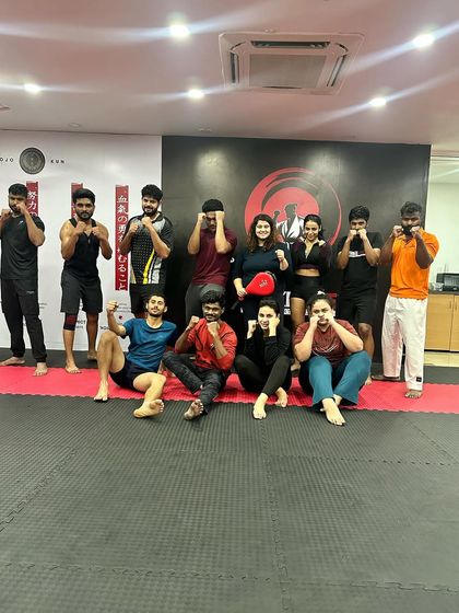 Another post-training shot, with one member playfully holding up a kicking pad.