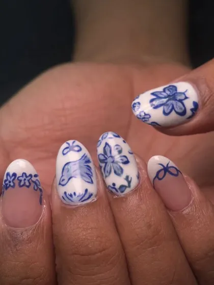 A detailed view of the hand-painted blue pottery art, showing the fine brush strokes on the bird and flowers.
