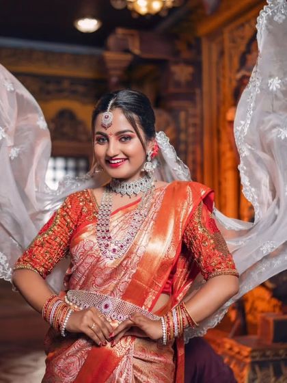 A full, joyful portrait of a bride in our ruby and diamond-look set. The matching Vaddanam and bangles complete this stunning reception ensemble.