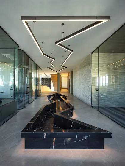 For this algorithmic trading house, I created a central passage that is both functional and artistic. The zigzagging black marble seating is mirrored by a custom overhead lighting fixture, guiding movement through the space while reflecting the dynamic nature of the business.