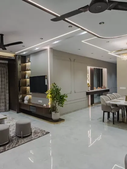 This modern residential space seamlessly integrates a living and dining area with an open-plan layout, emphasizing functionality and elegance. Design elements like sleek lighting, built-in shelves, and mirrored accents enhance spaciousness and visual appeal.