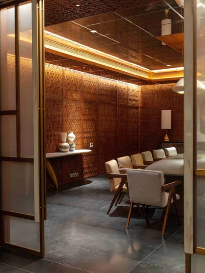 The entrance to the Bammi dining room, framed by sliding screens that continue the home's theme of layered discovery. The intricate lattice work is visible, hinting at the special space within.