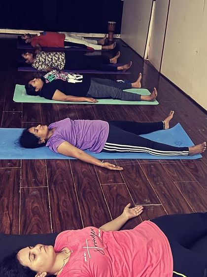 A moment of deep relaxation in Savasana, or corpse pose, at the end of a class. This is where the body absorbs the benefits of the practice, guided by gentle instruction and stillness.