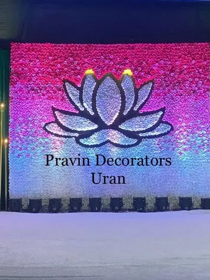 An LED screen can be a great focal point. This engagement stage features a large screen displaying a lotus graphic, flanked by elegant gold candle-wall panels and chandeliers, creating a vibrant and modern look.