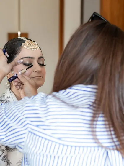 This is me in my element. A behind-the-scenes shot of me applying mascara to a bride, showcasing the focus and gentle touch I bring to every single client to ensure they feel comfortable and look perfect.