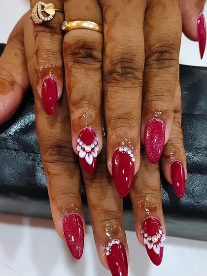I created this bold and dramatic bridal nail set using a vibrant red polish. The look is enhanced with intricate 3D white floral patterns and sparkling stones, designed to make a statement.