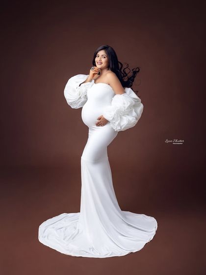 A little bit of movement in the hair and a confident pose bring this portrait to life. The contrast between the white gown and the rich backdrop makes the image pop.