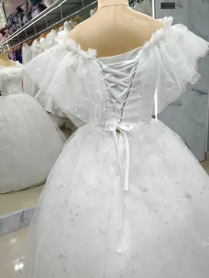 The back of the fairytale tulle gown, showing the classic corset lacing that allows for a perfectly sculpted fit. The ruffled sleeves add a touch of whimsical charm.