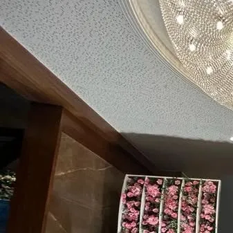 A detail shot showing the venue's architecture, including the grand chandelier and a glimpse of a floral panel we installed. We always consider the existing space when designing our decor.