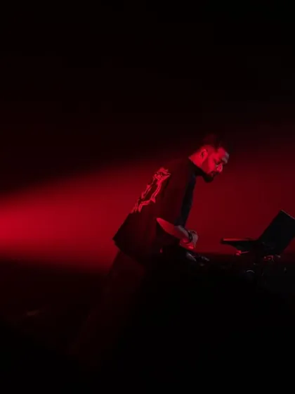 A dramatic silhouette under a single red spotlight. Sometimes, less is more when it comes to stage presence.