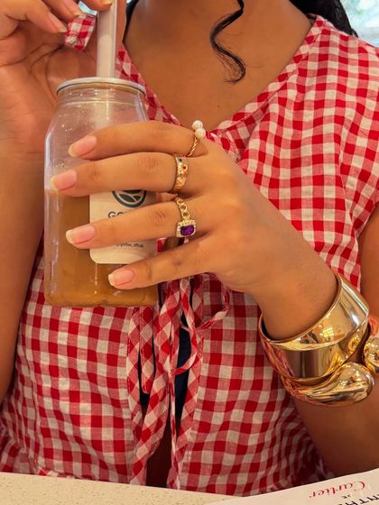 A detailed shot of my hands, showing off my rings and the texture of my iced coffee bottle. It’s an aesthetic, detail-oriented shot.