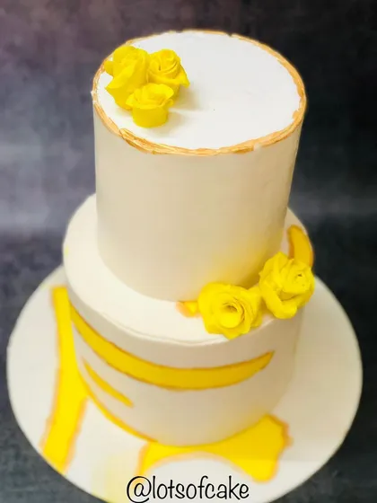 This two-tiered cake is a perfect example of classic elegance. I used a clean white buttercream base with delicate yellow sugar flowers and subtle gold accents for a timeless look, ideal for weddings or milestone anniversaries.
