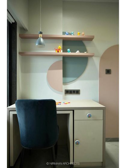The study nook in this toddler's room is designed at a child-friendly height. The soft colors and simple shapes create a welcoming space for learning and creativity.