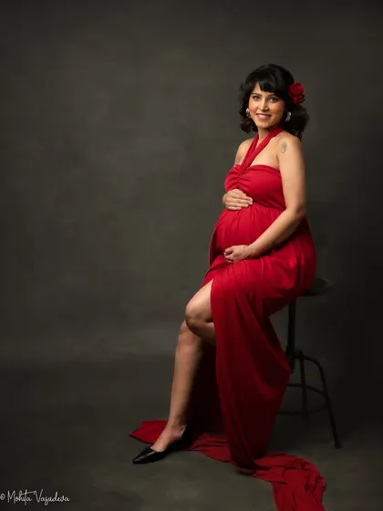 A touch of classic Hollywood glamour with a red flower in her hair. This pose is both playful and elegant.