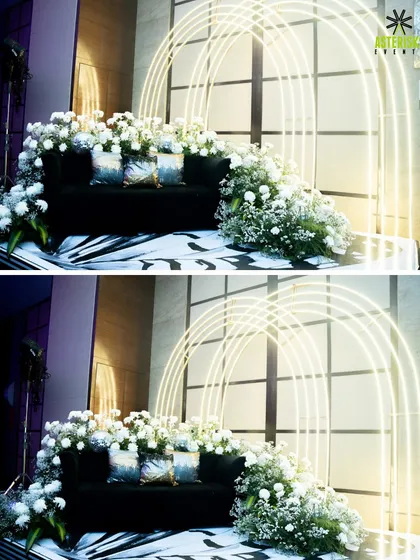A chic and modern photo booth for a cocktail night, featuring a black sofa, white florals, and elegant neon arches.