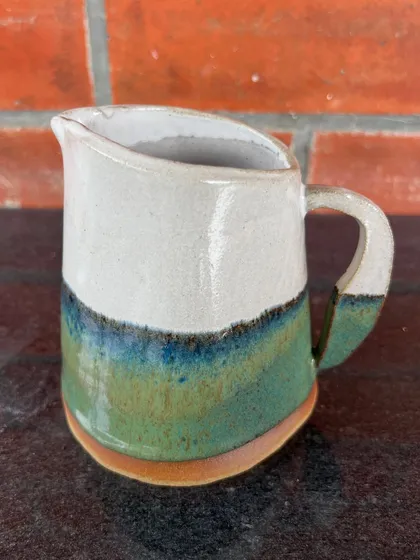 A sweet little milk pitcher with a beautiful, flowing glaze. This was another piece from a student's 15-day hand-building journey.