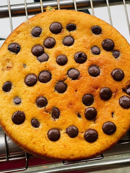 A simple classic, this is my eggless chocolate chip butter cake cooling on a rack. It's soft, buttery, and packed with chocolate chips in every bite, perfect for an afternoon snack.