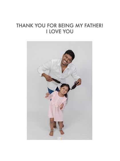 A playful father holds his daughter's pigtails, a funny and memorable moment from their photoshoot.