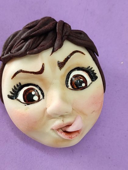 The hand-sculpted, expressive face I made for my own caricature on the topsy-turvy baker cake.