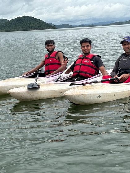 A group of kayakers takes a break on the water, enjoying the calm and scenic environment.