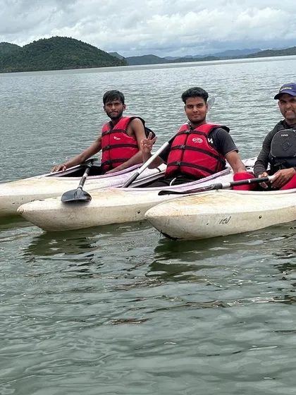 An instructor paddles alongside two participants, offering tips and guidance during a session at Vani Vilas Sagar.