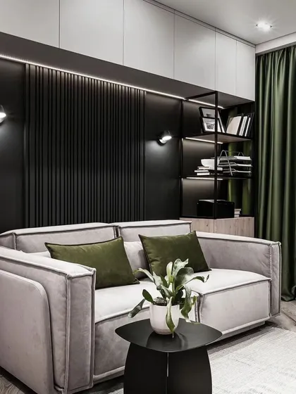 A cozy living room nook with a grey sofa set against a dark, fluted accent wall. The open metal shelving provides a modern and industrial touch for display.