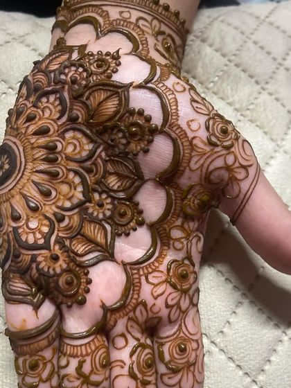 A close-up of a beautiful mandala design on the palm, a classic element in Indian mehendi.