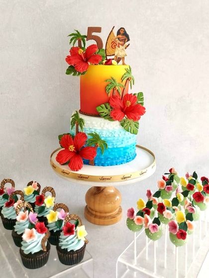 The Disney themes are just timeless. This Moana-themed birthday cake features a two-toned buttercream finish to look like the sea and sunset, complete with handmade hibiscus sugar flowers and matching cupcakes and cake pops.