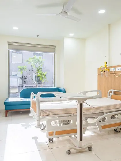 A view of a patient room at Sarvesh Health City, designed for comfort and functionality. The large window provides natural light and a connection to the outside, which is proven to aid in recovery.