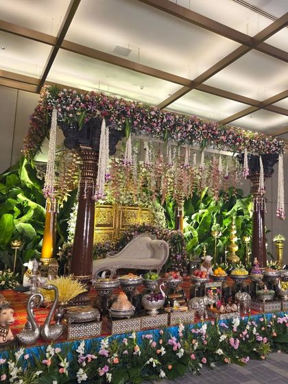 An angled shot of the traditional mandapam, showing its sturdy structure and the rich combination of wood, flowers, and greenery.
