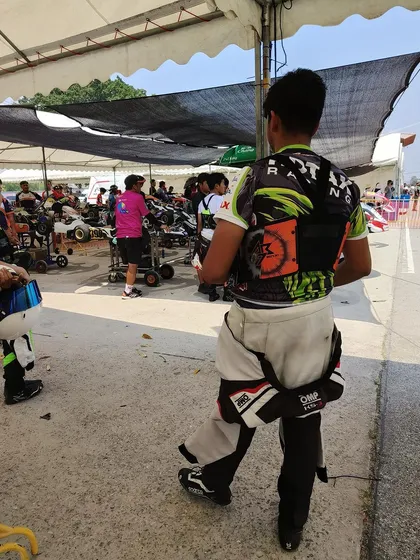 A driver gets ready in the pit area.