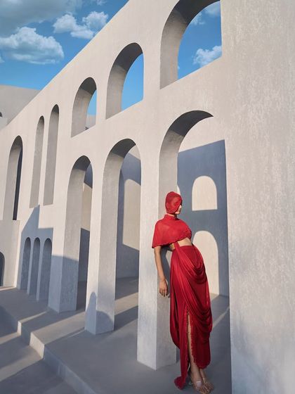 Grace meets grandeur in this breathtaking red ensemble, featuring a beautifully crafted double drape skirt and a delicate, embroidered mesh bodice.
