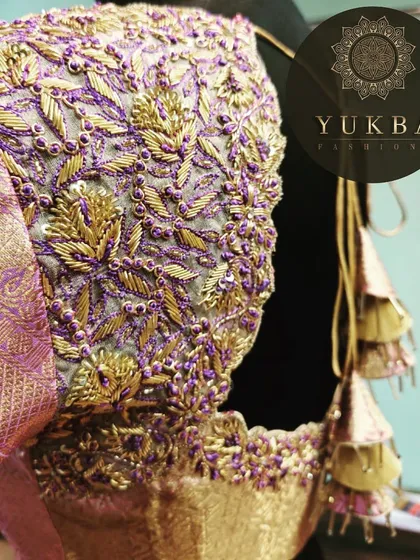 A close-up of a lavender blouse with dense gold and purple leaf-patterned embroidery. This puff-sleeve design shows the rich texture and detail I bring to custom bridal wear.