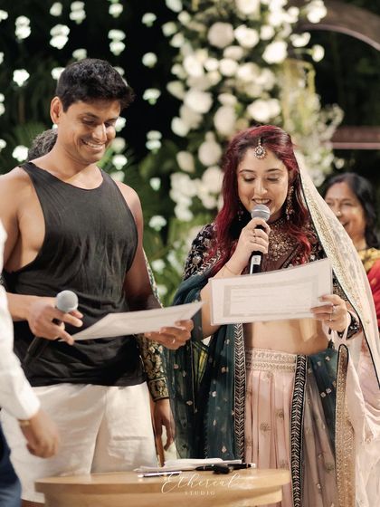 The bride and groom reading their vows from the official register, a blend of formal duty and personal joy. The groom's unconventional attire makes the moment even more memorable.